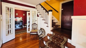 A staircase with a wooden handrail and a dark wall on one side. - Chestnut Inn Bed and Breakfast (Niagara Falls)