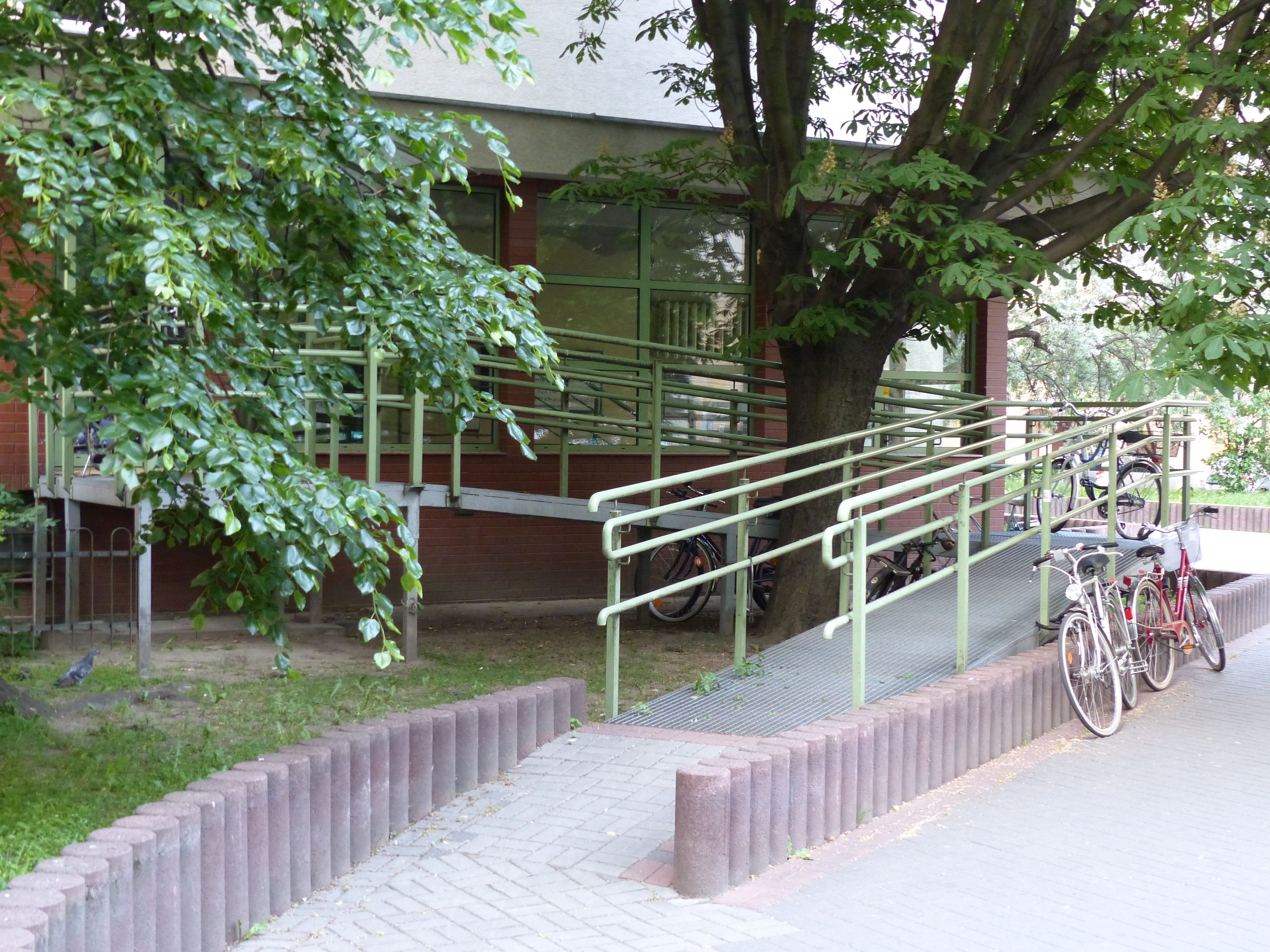 A staircase leading to a building with a tree in the foreground.