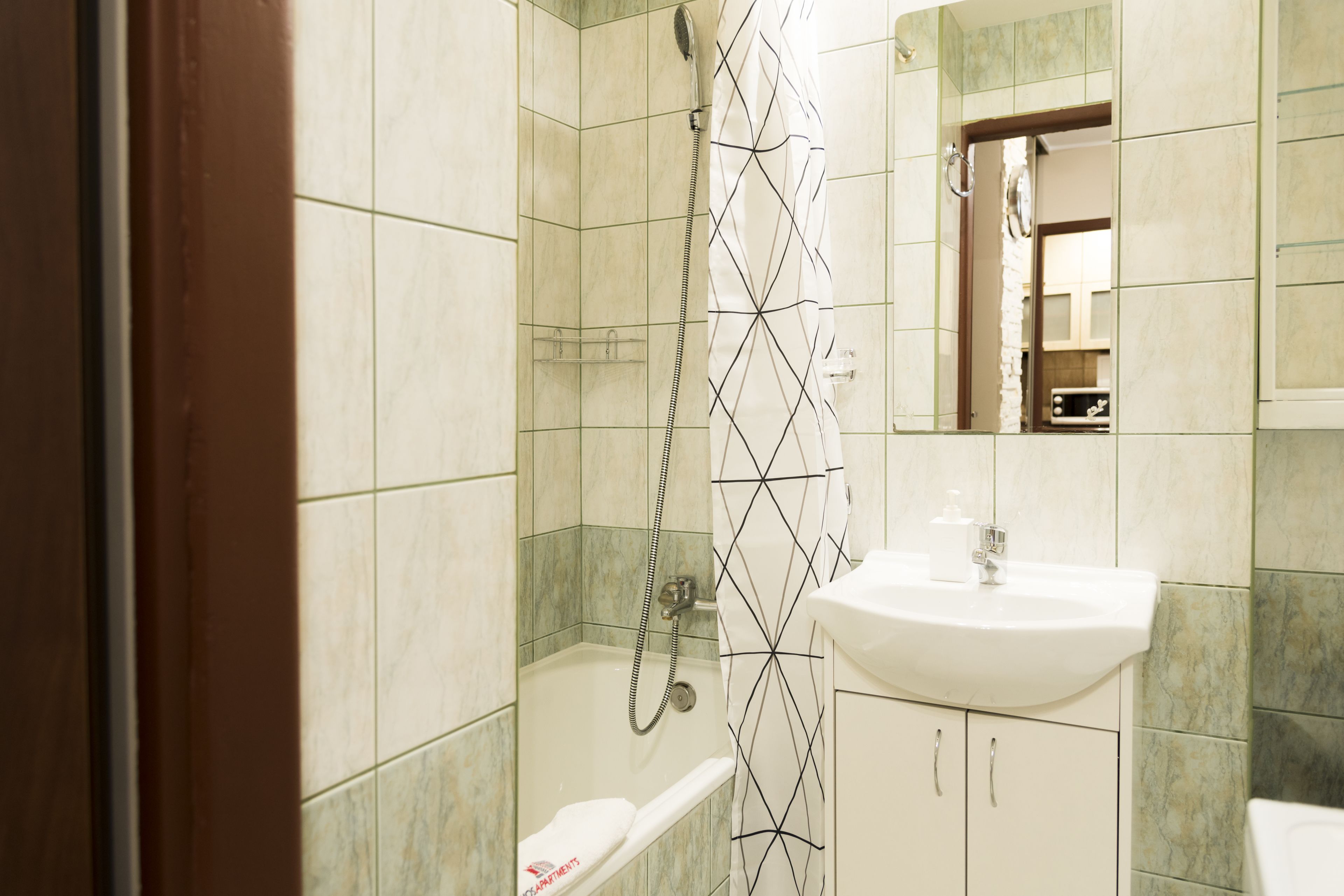 Un bagno con doccia, lavandino e WC.