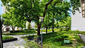 A landscaped garden with pathways, trees, and a lamppost.