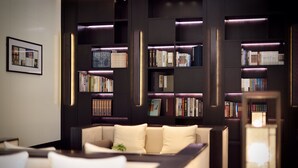 A modern library with bookshelves, a sofa, and a framed picture on the wall. - Relais & Chateaux Yihe Mansions (Nanjing)