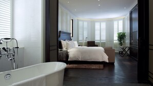 A modern bedroom with a large bed, a bathtub, and a view of the outdoors through large windows. - Relais & Chateaux Yihe Mansions (Nanjing)