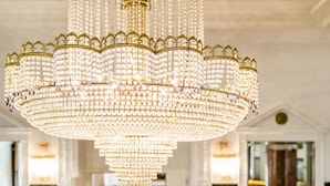 A large, ornate chandelier with multiple tiers of crystal and gold detailing. - Grand Hotel Bellevue - adults only (Merano)