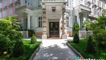 A grand hotel entrance with a prominent sign reading "BELLEVUE GRAND HOTEL".