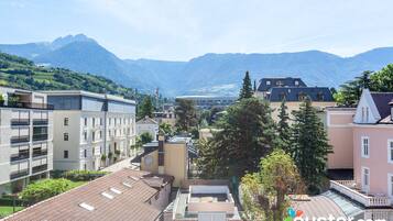 A hotel with a view of mountains, featuring modern architecture and a mix of balconies and terraces.