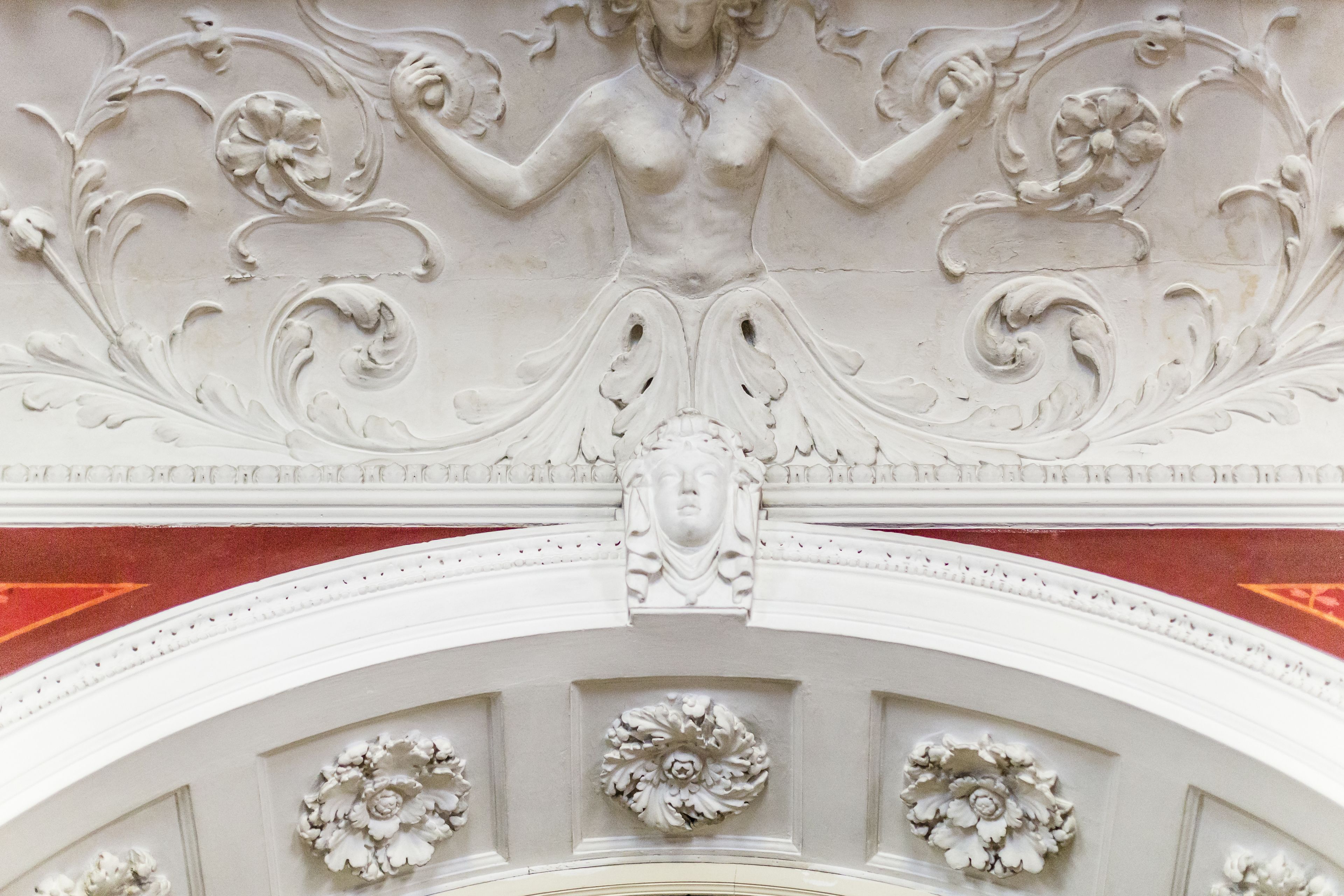 A detailed architectural ceiling with ornate carvings and floral motifs.