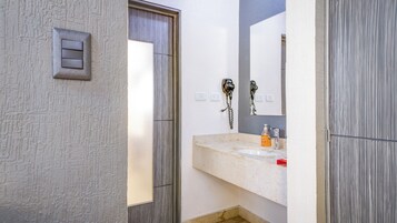 Un baño con encimera de mármol, un espejo, un teléfono y un interruptor de luz.