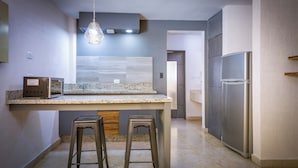 Une cuisine moderne dotée de plans de travail en granit, d’appareils électroménagers en acier inoxydable et d’un luminaire suspendu.