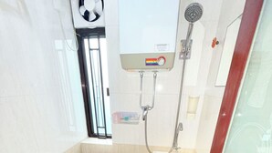 A compact bathroom with a toilet, sink, and shower. - Apple Hostel (Kowloon)