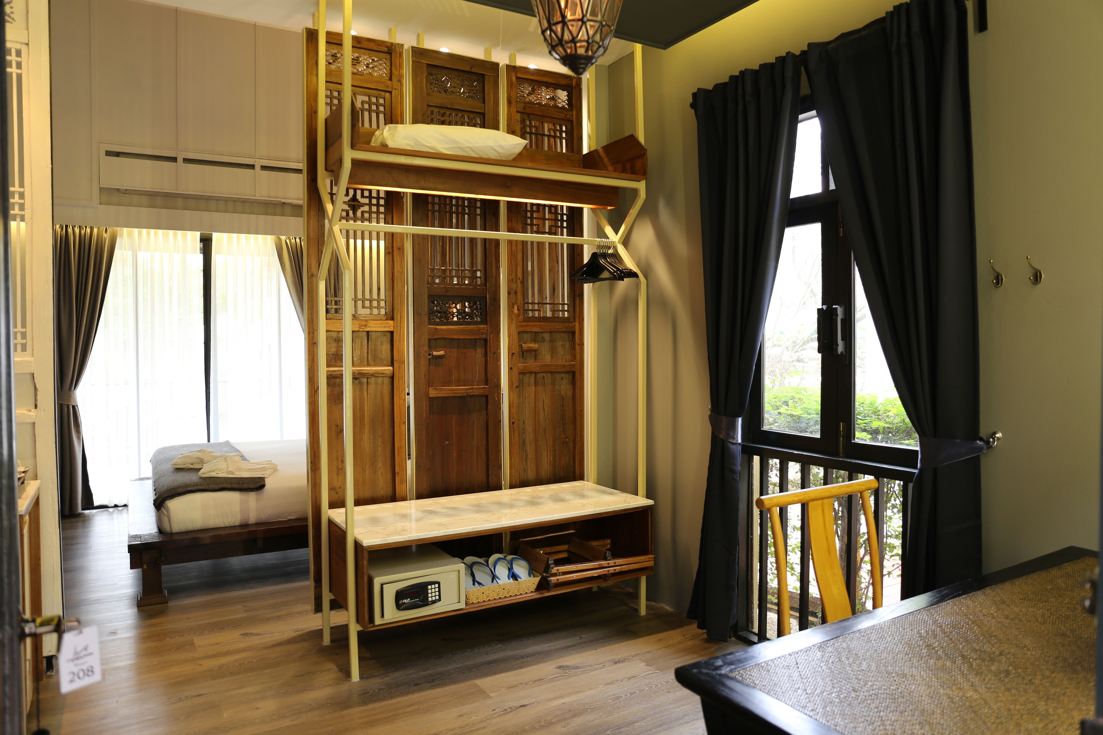 A room with a bunk bed, a desk, a chair, and a window with curtains.