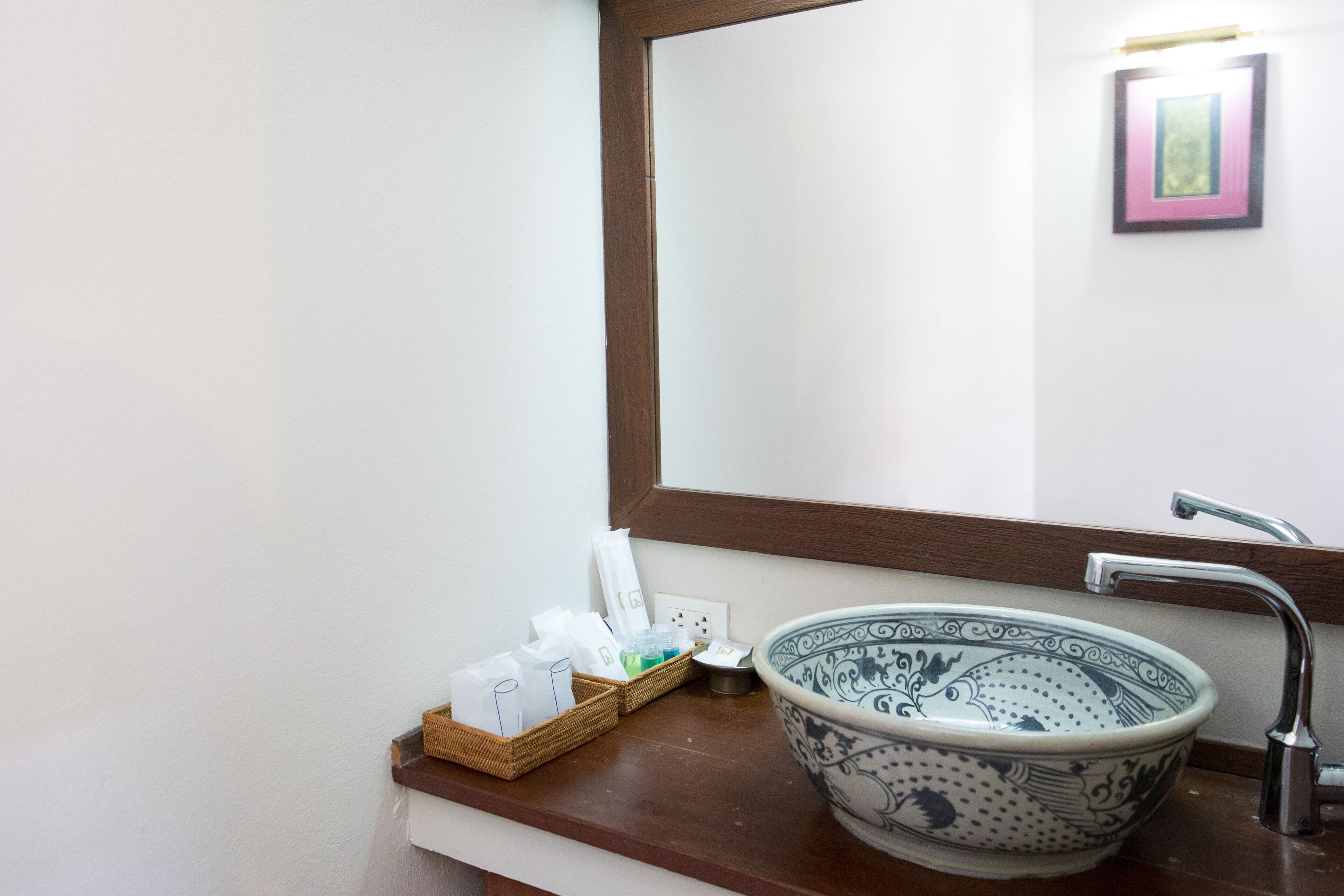 A bathroom with a large decorative bowl sink, a mirror, and a wooden countertop.