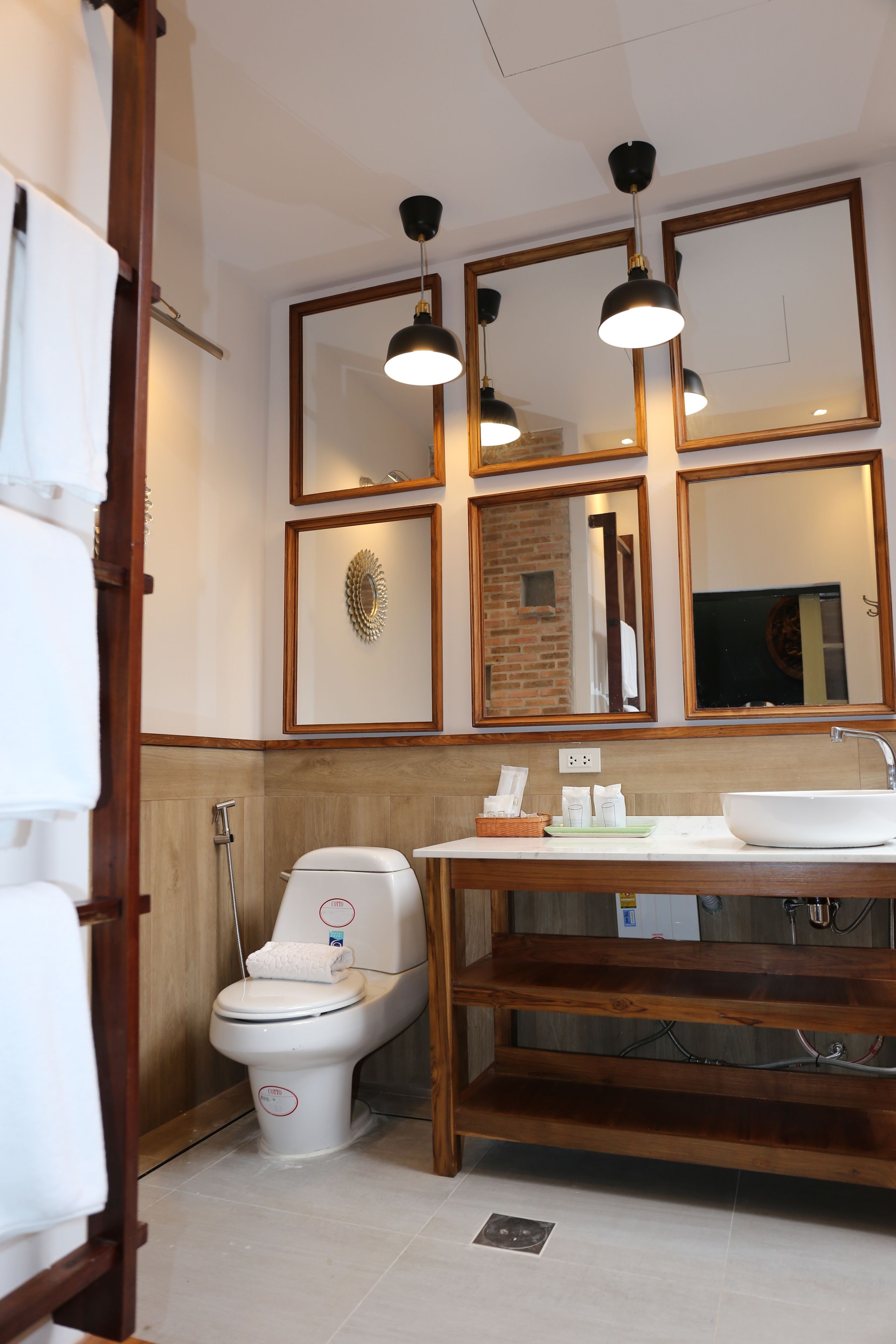 A bathroom with a toilet, sink, and mirrors.