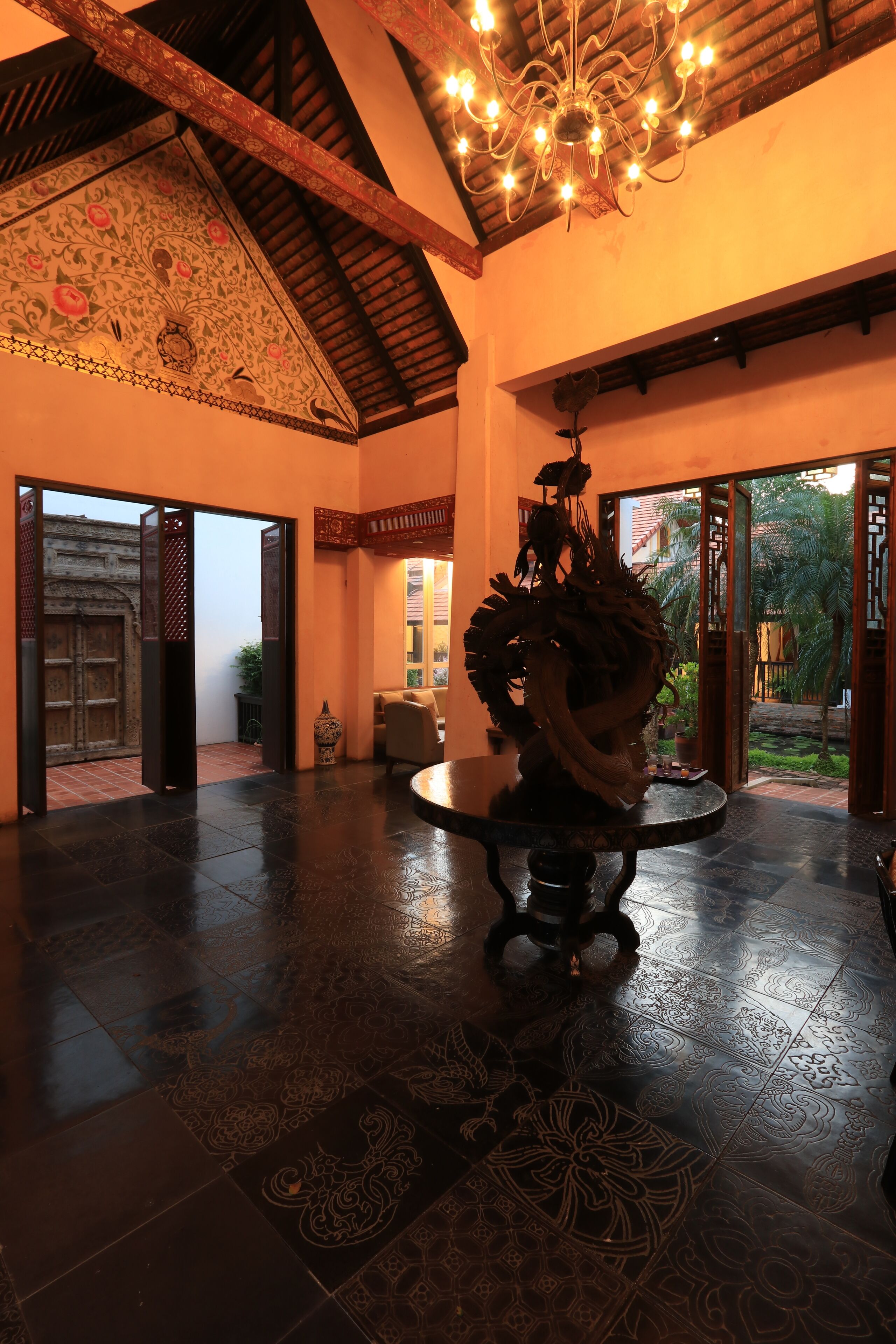 A spacious lobby with a high ceiling, ornate ceiling design, and a central decorative sculpture.