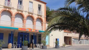 A building with a blue storefront and a sign reading "CAPE DES ARTS CADES". - Hotel Résidence BEAR (Port-Vendres)