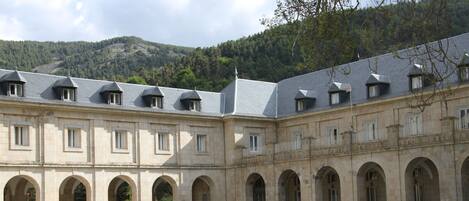A historic building with a courtyard, arched windows, and a central pool.