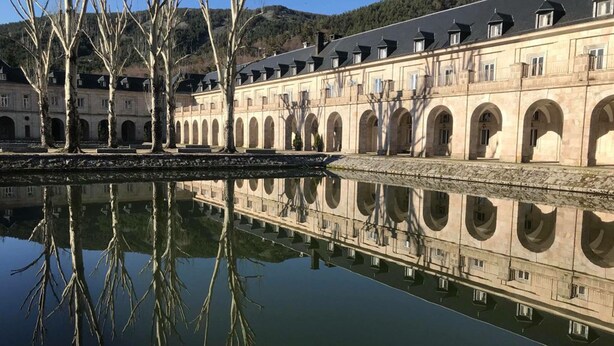 Ein historisches Gebäude mit Bogenfenstern und Spiegelung im Wasser.