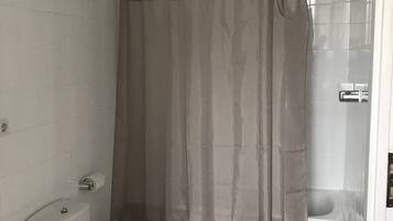 Een badkamer met toilet, bidet en douchegordijn.
