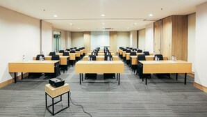 A conference room with multiple tables and chairs, equipped with water bottles and nameplates. - Hotel Citradream Semarang (Semarang)