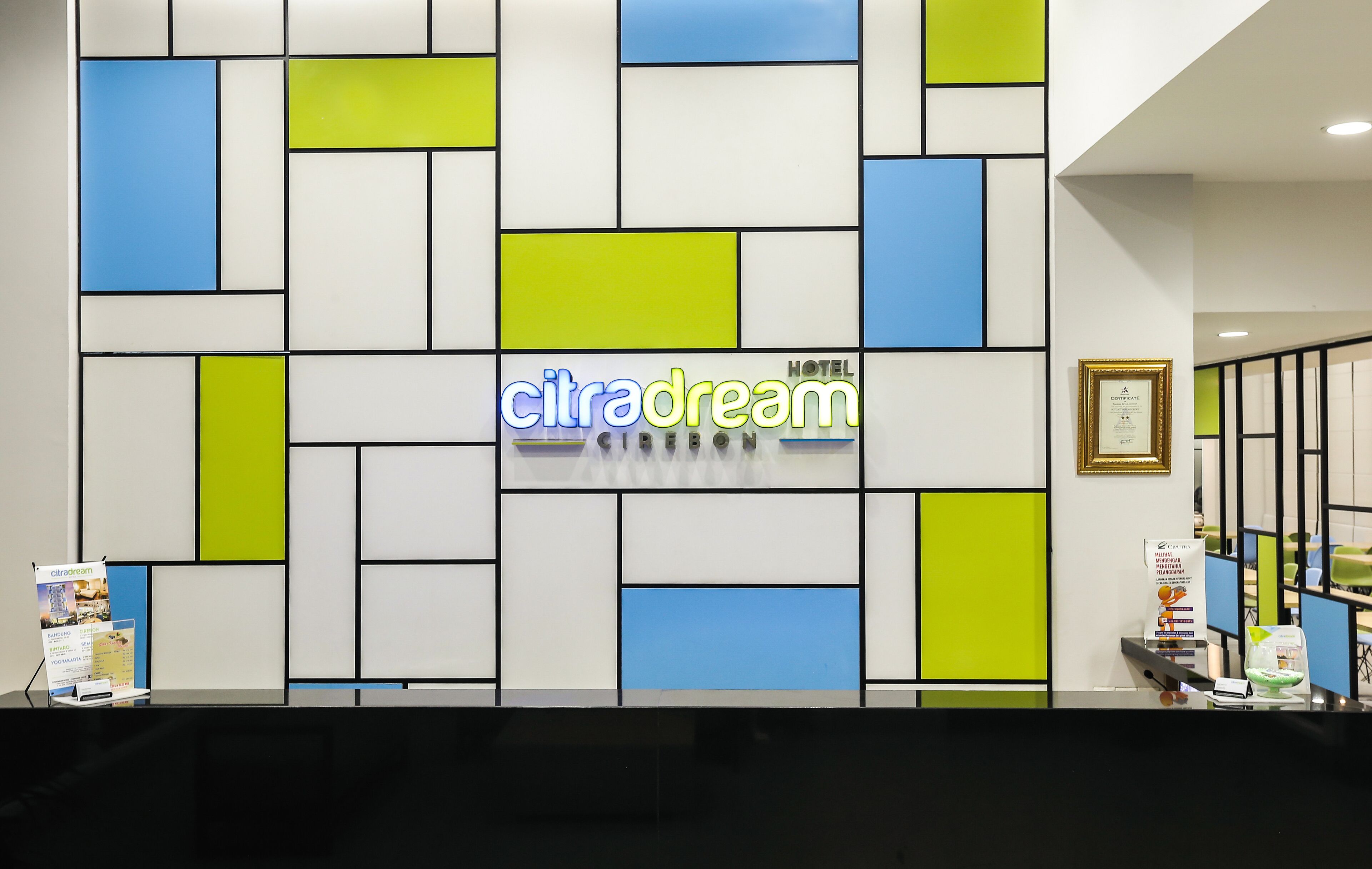 A reception area with a geometric wall design, a sign reading "citradream," and a framed certificate on the wall.