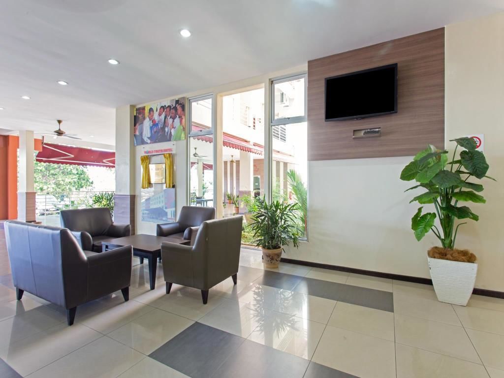 A reception area with leather sofas, a flat-screen TV, and potted plants.