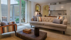 A modern living room with a sofa, coffee table, and a dining area with a table and chairs.