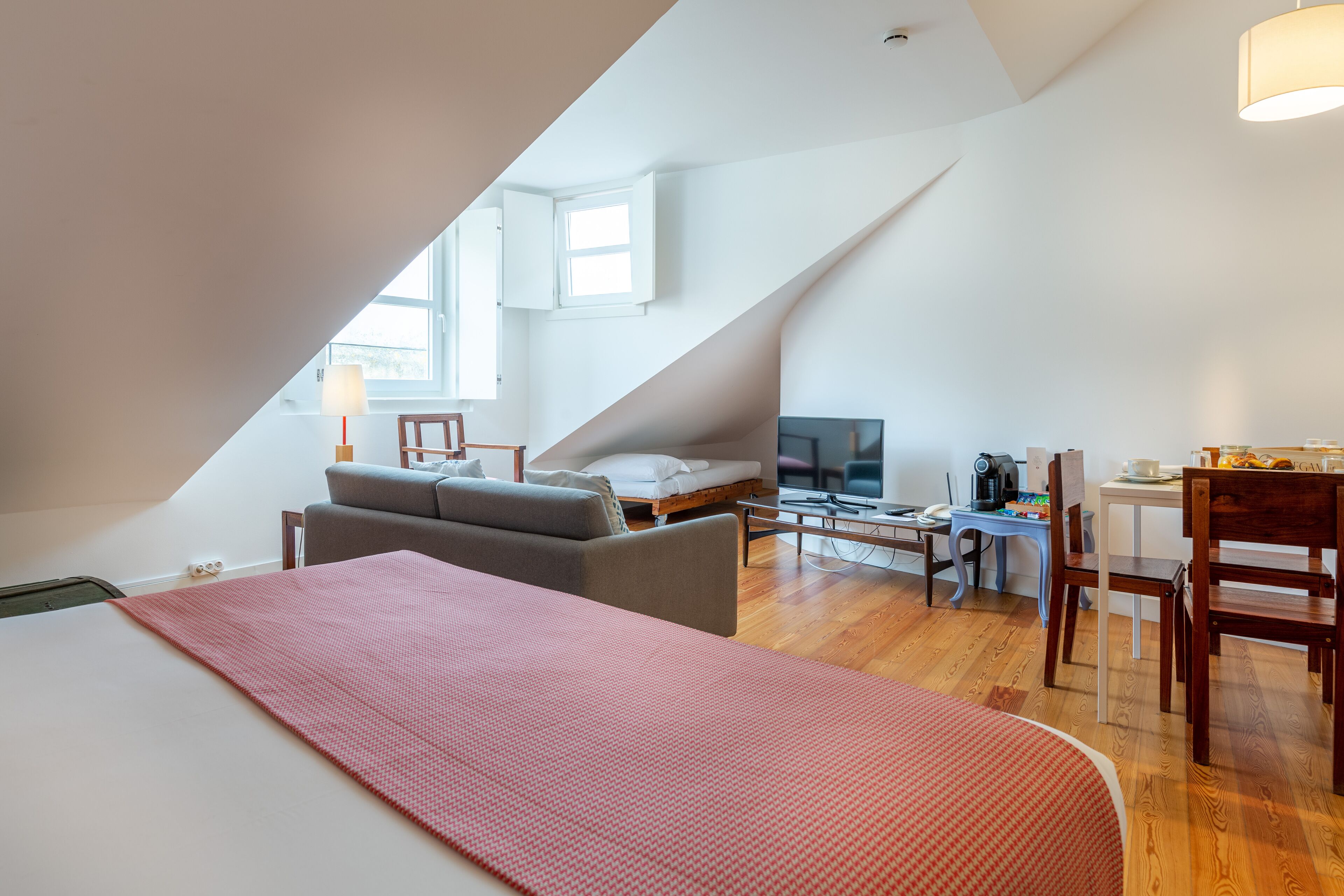 Een moderne loft slaapkamer met een groot bed, een bureau en een televisie.