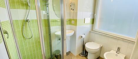 Un baño con ducha acristalada, lavabo, inodoro y bidé.
