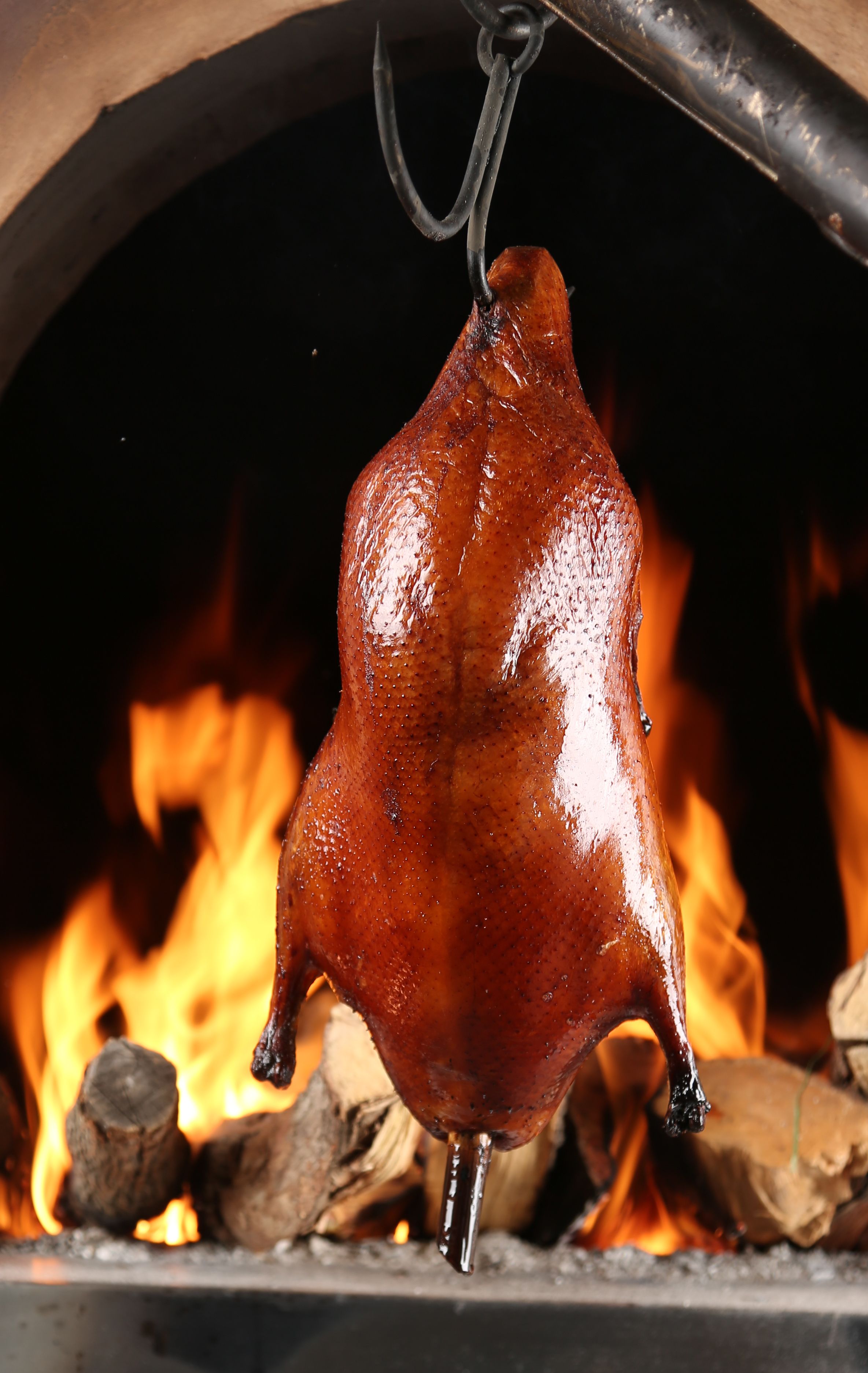 Un cerdo asado colgando sobre el fuego.