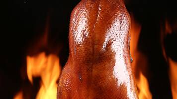 Un cerdo asado colgando sobre el fuego.