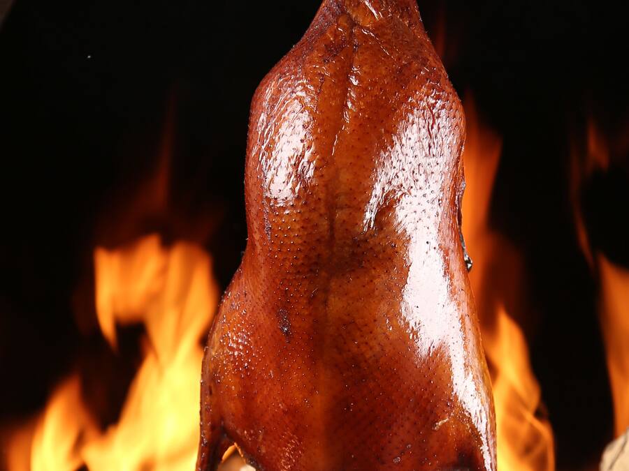 Un cerdo asado colgando sobre el fuego.