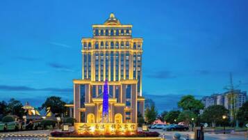 Un edificio grande de varios pisos con una fuente central y un jardín bien cuidado.