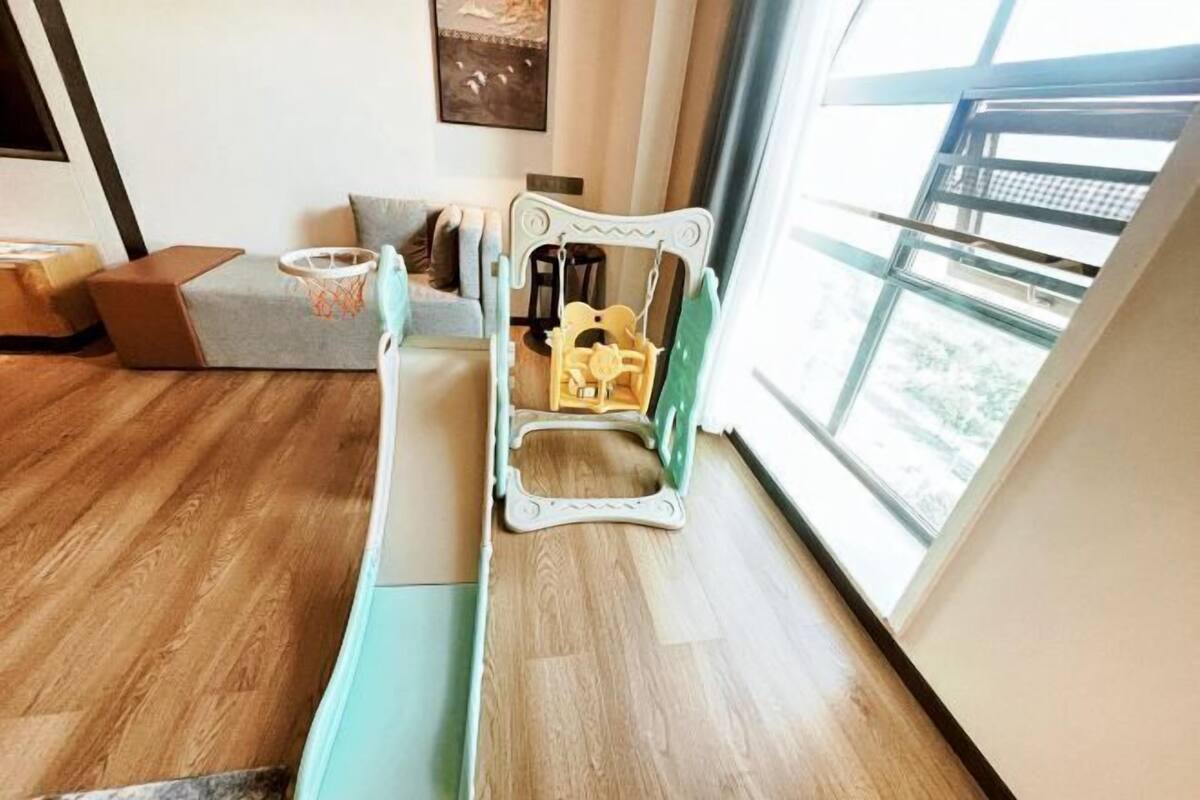 Ein Zimmer mit Holzboden, einer gepolsterten Bank, einem kleinen Tisch und einem Fenster mit Blick.