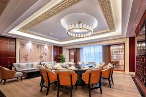 A dining area with a round table, chairs, and a chandelier. - Nanxi Juyang Hotel (Yibin)