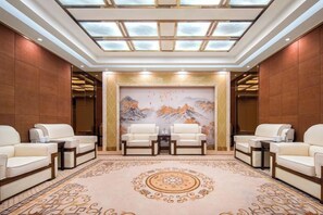 A spacious lobby with a high ceiling, a large mural, and four seating areas. - Nanxi Juyang Hotel (Yibin)
