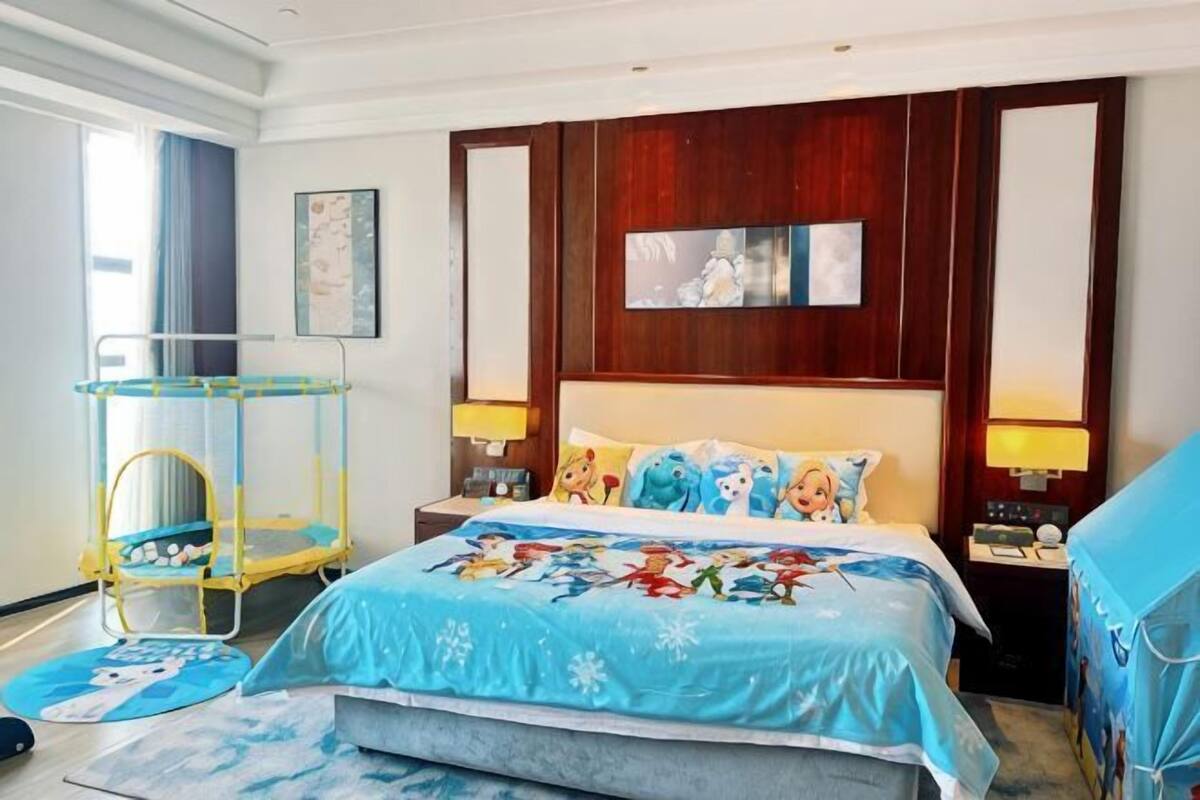 Ein Hotelzimmer mit einem großen Bett, einem Holzkopfteil, einem Nachttisch, einer Lampe, einem kleinen Tisch und einem Stuhl.