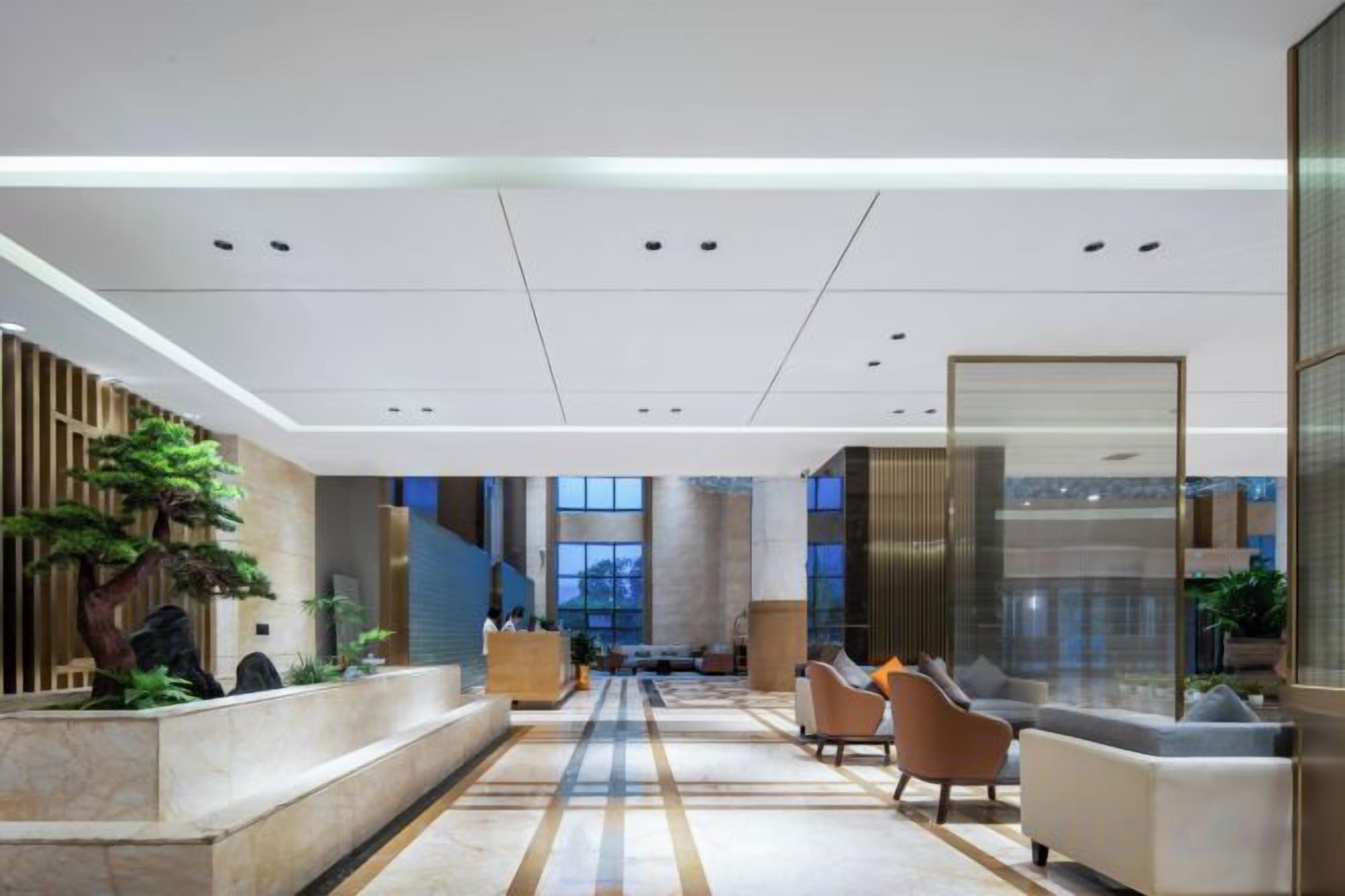 Un vestíbulo moderno con una recepción, zona de estar y una escalera que conduce a los pisos superiores.