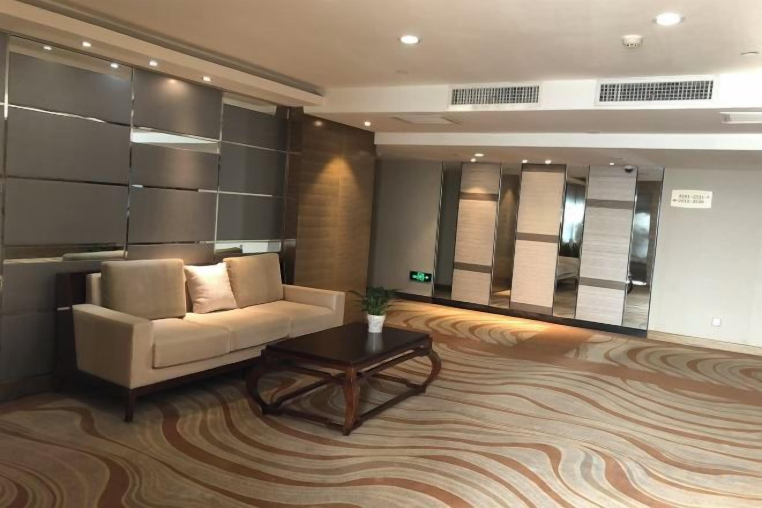A lobby with a sofa, a coffee table, and a patterned carpet.