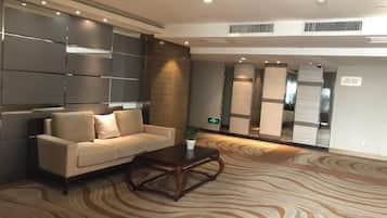 A lobby with a sofa, a coffee table, and a patterned carpet.