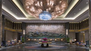 A spacious lobby with a large, ornate chandelier, a reception desk, and seating areas. - Wanda Vista Kunming (Kunming)