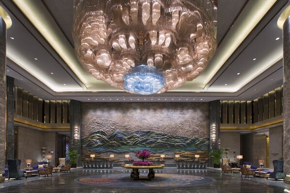 A spacious lobby with a large, ornate chandelier, a reception desk, and seating areas. - Wanda Vista Kunming (Kunming)