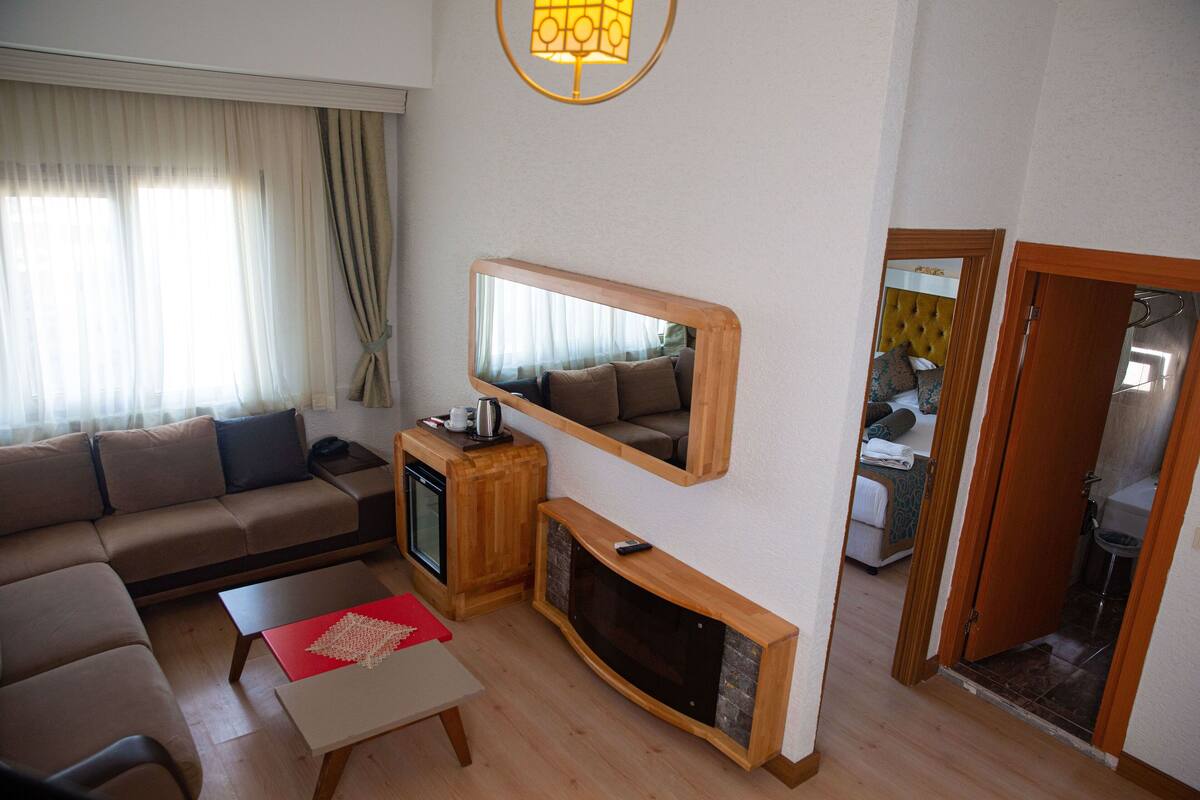 Un salon avec un canapé, une table basse, une cheminée et un miroir.