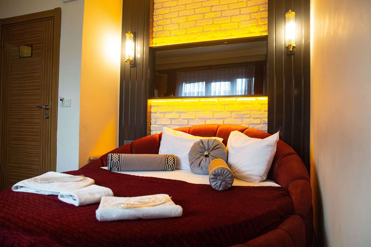 Une chambre d’hôtel avec un grand lit, un mur en briques et deux lampes fixées au mur.