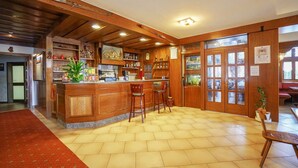 Un coin bar accueillant, avec des meubles en bois, un comptoir et des étagères remplies de bouteilles.