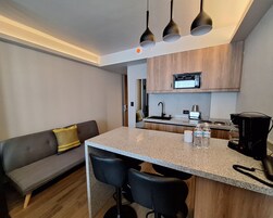 Una cucina compatta con un'isola centrale, un forno a microonde integrato e una macchina per il caffè.