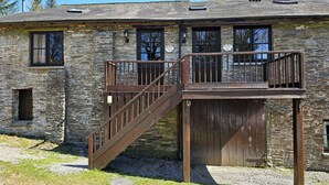 A stone building with a wooden staircase leading to a deck. - Simonsbath House (Minehead)
