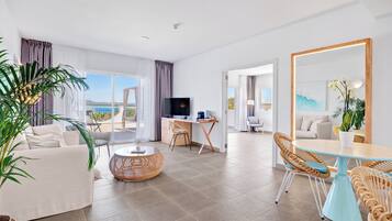 Una habitación de hotel moderna con balcón, comedor y zona de estar.