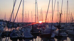 Un puerto deportivo con varias embarcaciones amarradas al atardecer.
