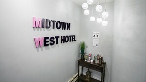 A hallway with a sign reading "MIDTOWN WEST HOTEL" and a wall-mounted sign indicating "STAIR | FLOOR A1". - Midtown West Hotel (New York)