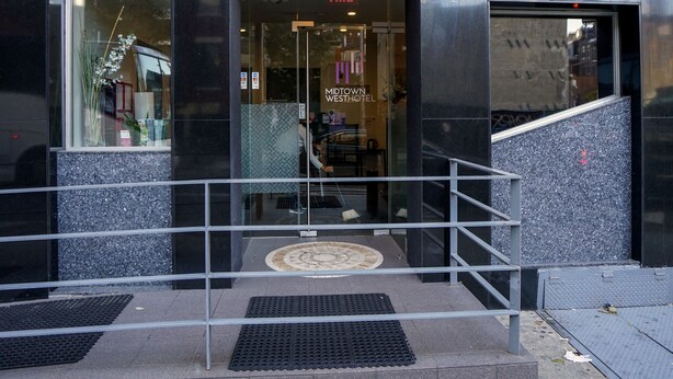 The exterior of the Midtown West Hotel with a clear entrance, a visible exit sign, and the address 303 W. - Midtown West Hotel (New York)