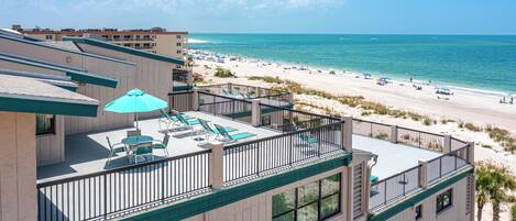 Un hotel con piscina en la azotea, vistas a la playa y un balcón con vista al mar.
